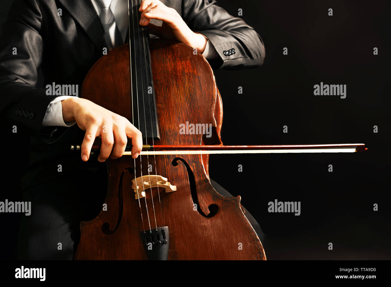 Man playing on cello on dark background Stock Photo