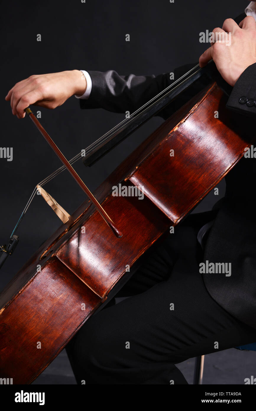Man playing on cello on dark background Stock Photo