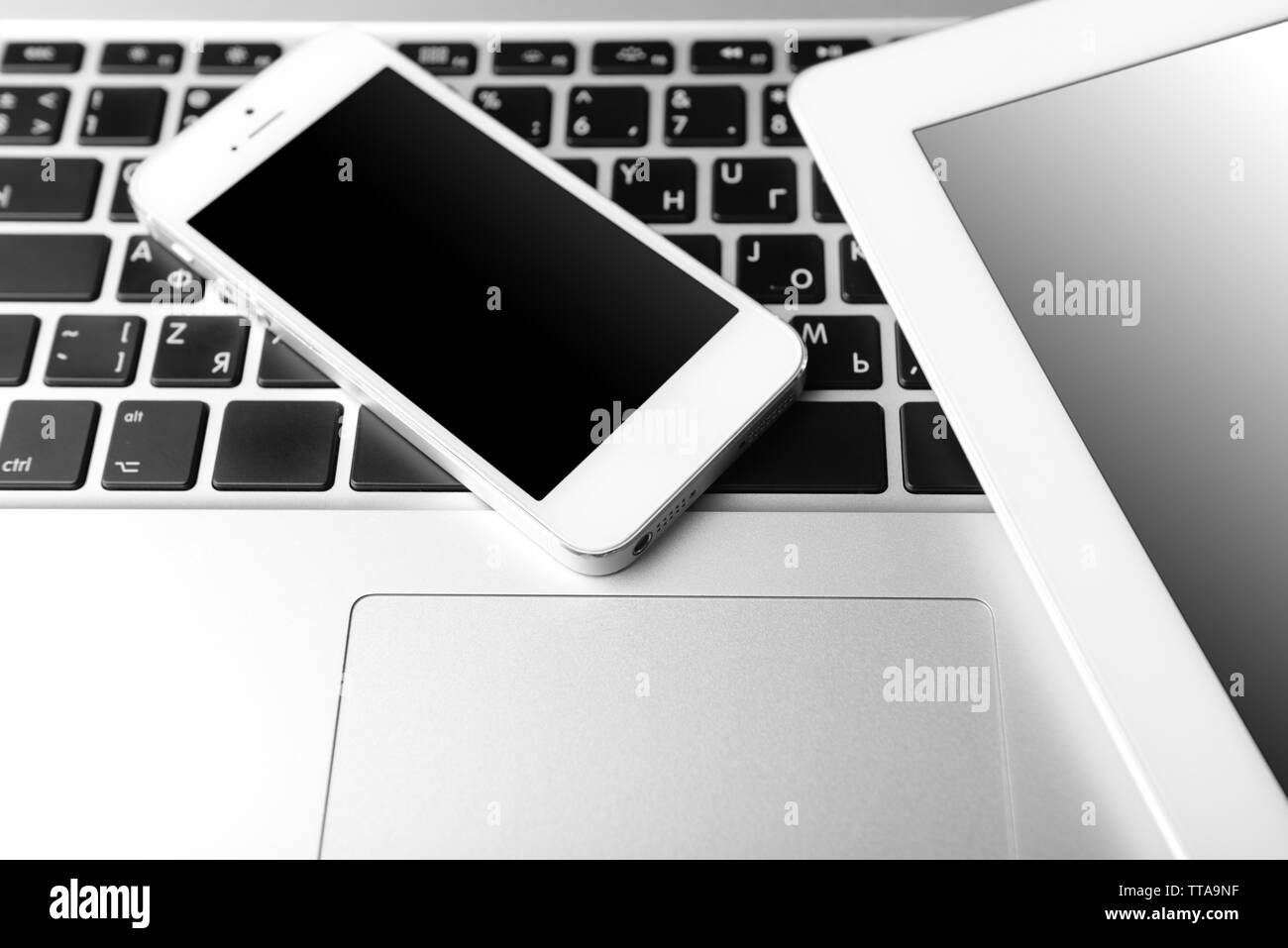 Tablet and mobile phone on keyboard, closeup Stock Photo