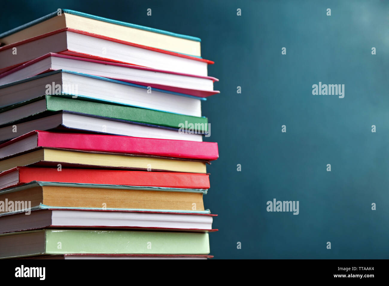 Stack of books on blackboard background Stock Photo - Alamy