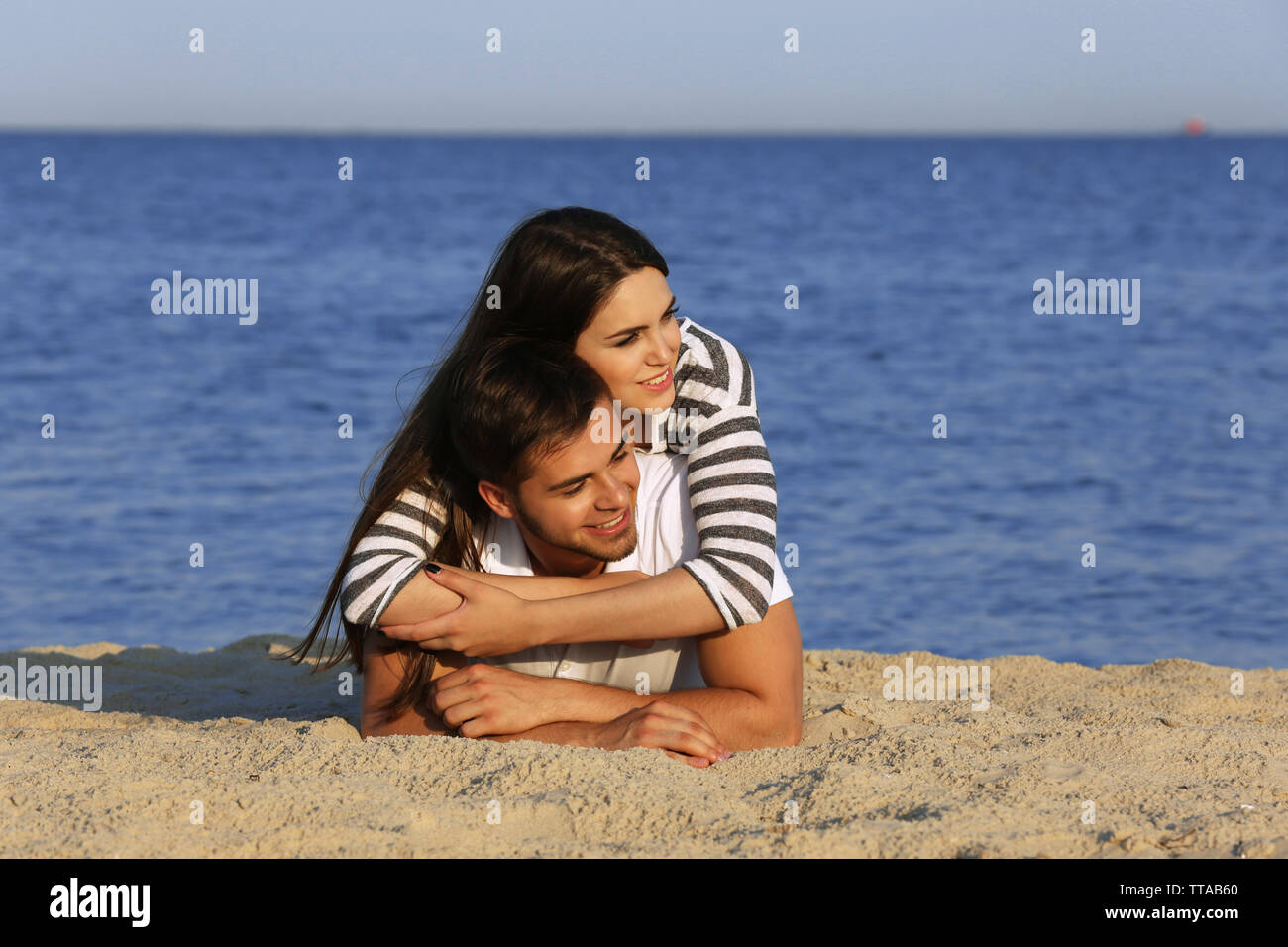 Young couple lying on beach Stock Photo - Alamy