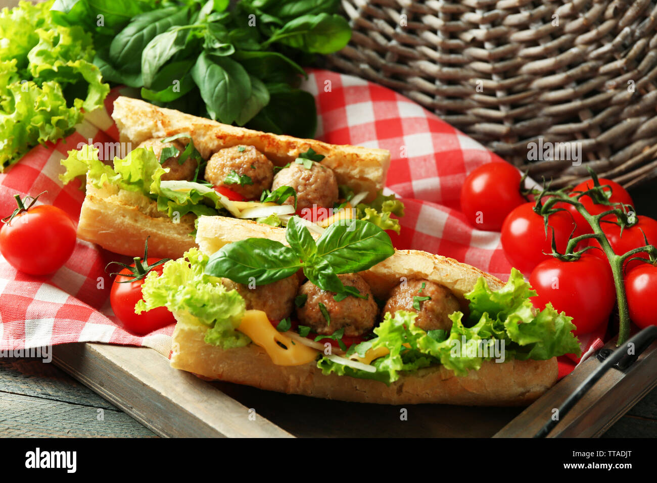 Homemade Spicy Meatball Sub Sandwich on tray, on wooden table