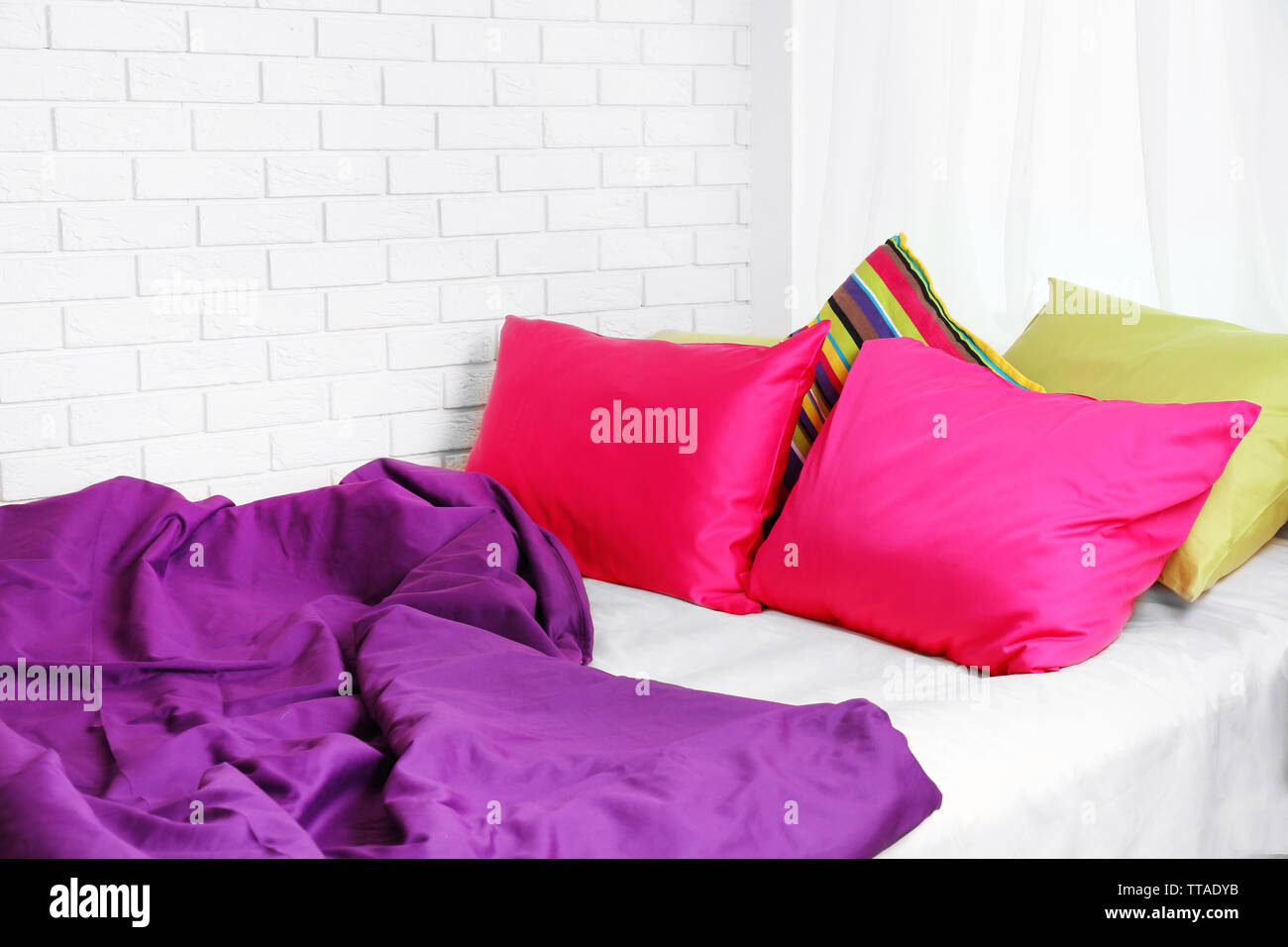 Comfortable bed with colorful pillows in bedroom Stock Photo Alamy