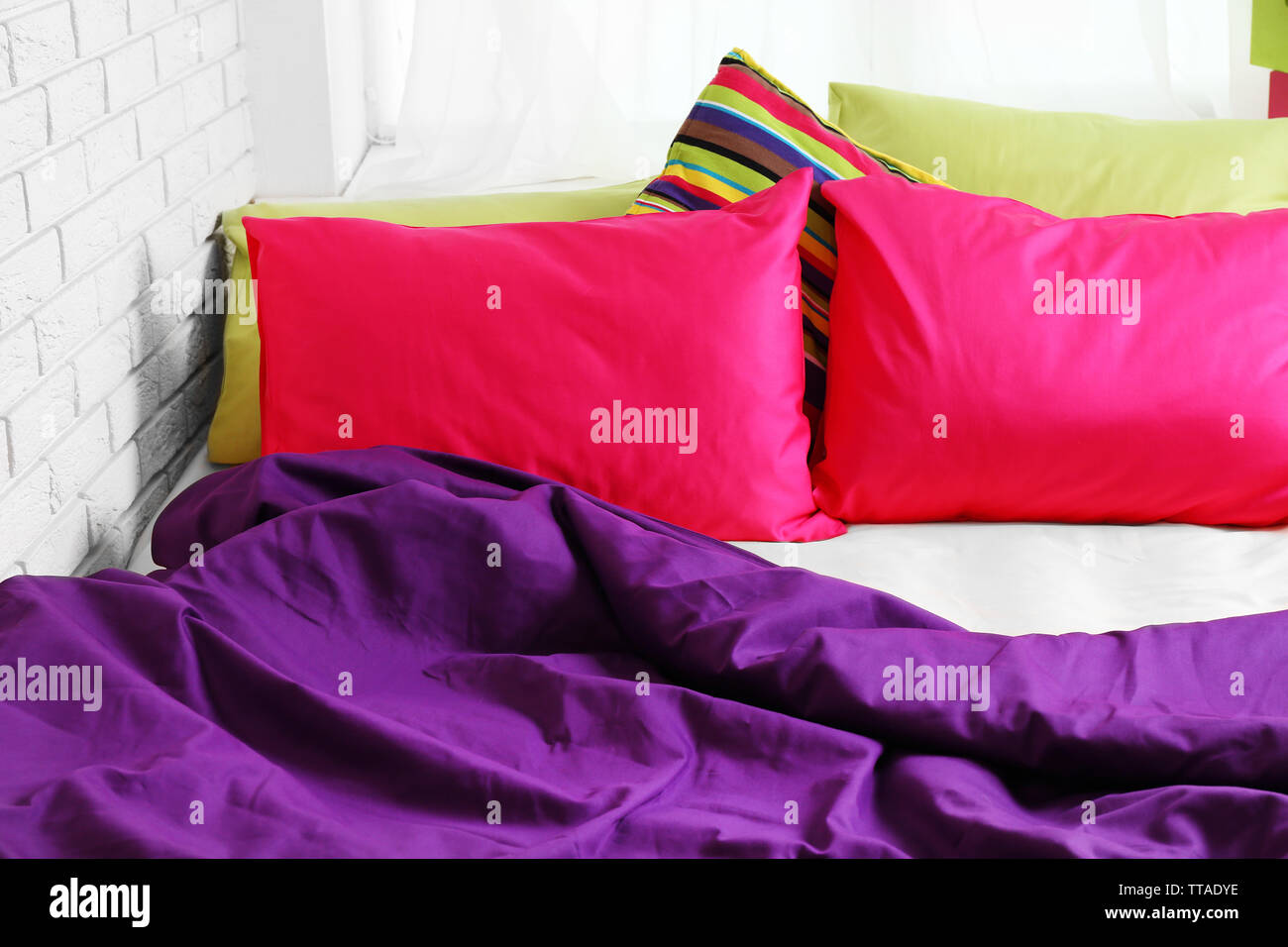 Comfortable bed with colorful pillows in bedroom Stock Photo Alamy