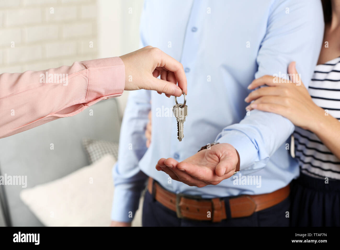 Real estate agent giving keys to young couple Stock Photo - Alamy