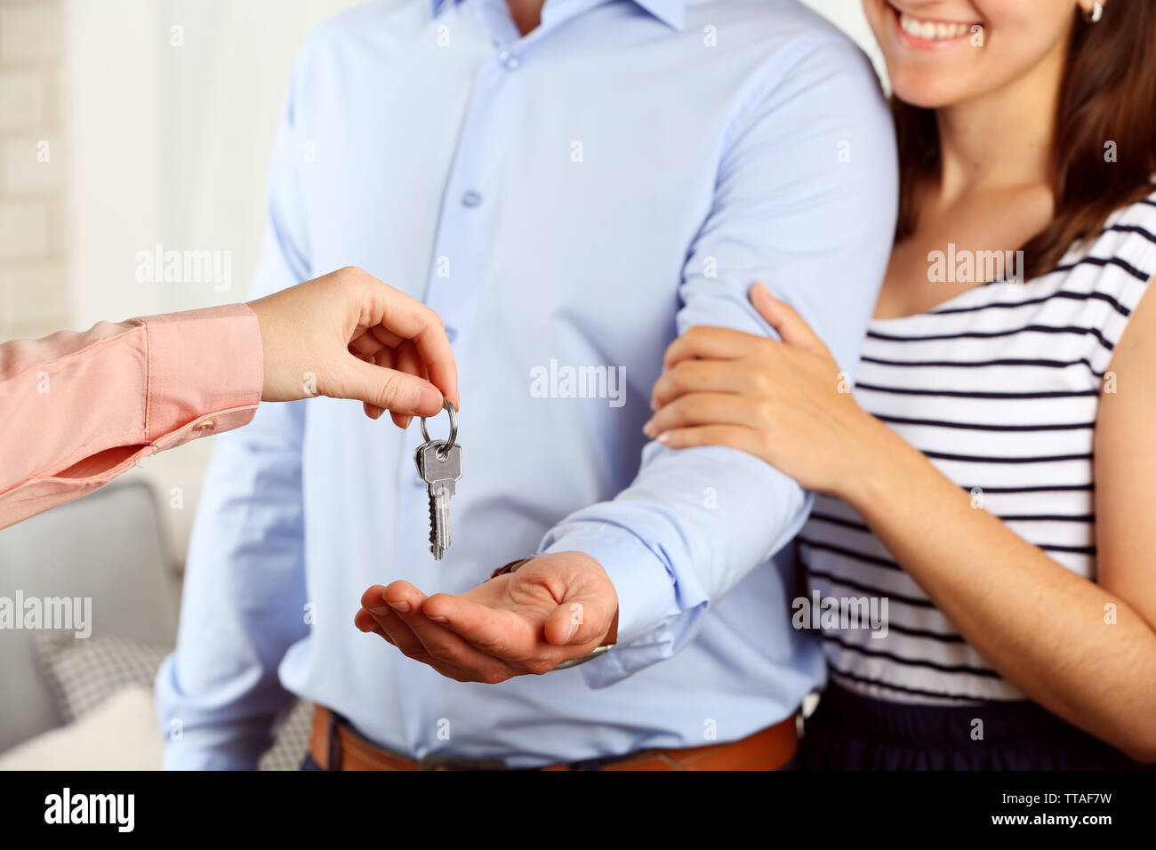 Real estate agent giving keys to young couple Stock Photo - Alamy