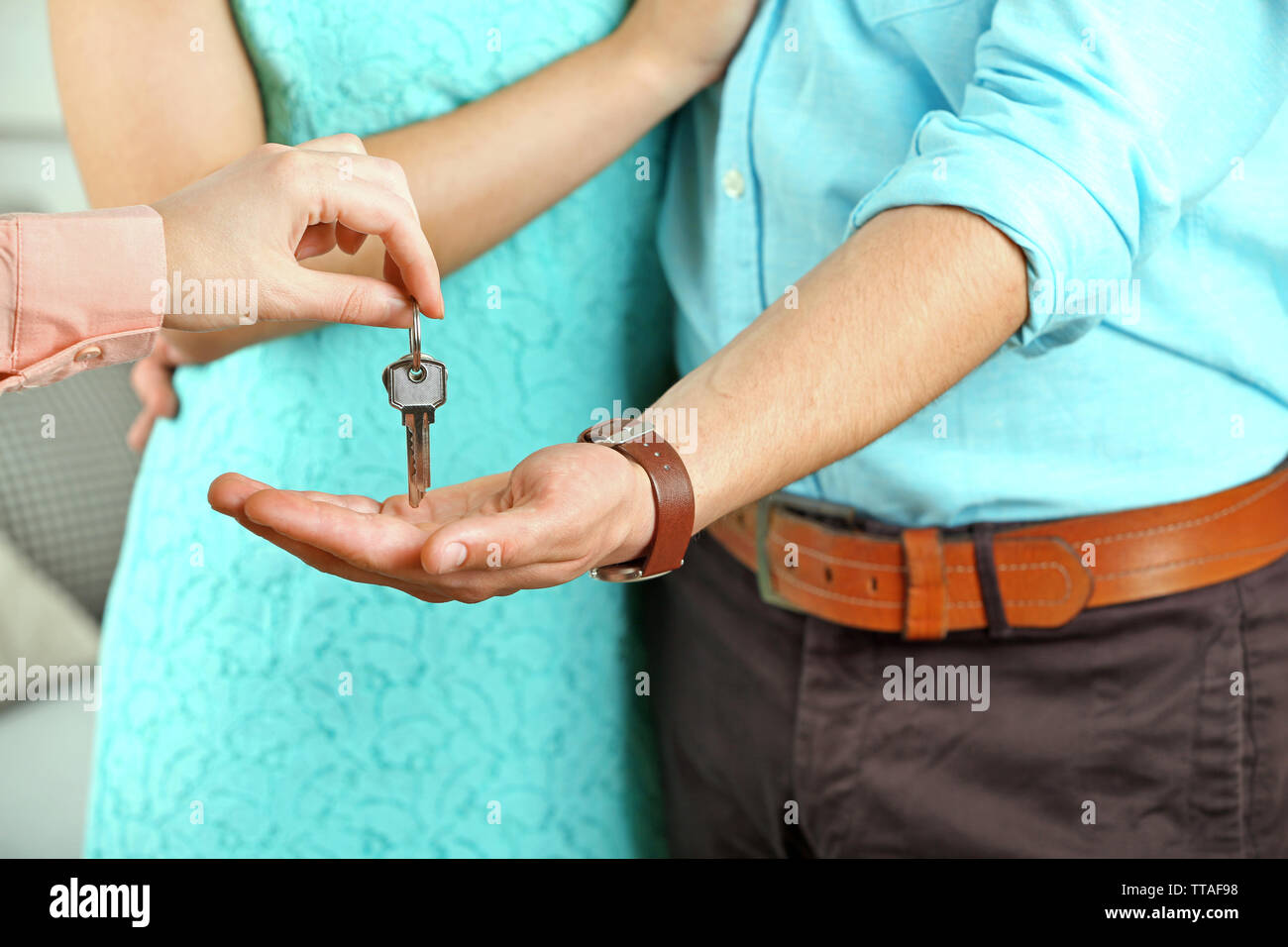 Real estate agent giving keys to young couple Stock Photo - Alamy