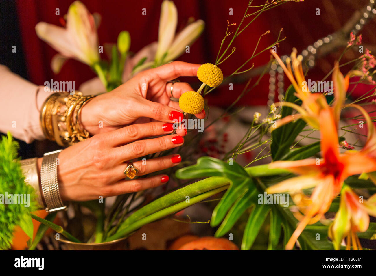 Hand holding flowers in front of autumn crops Stock Photo