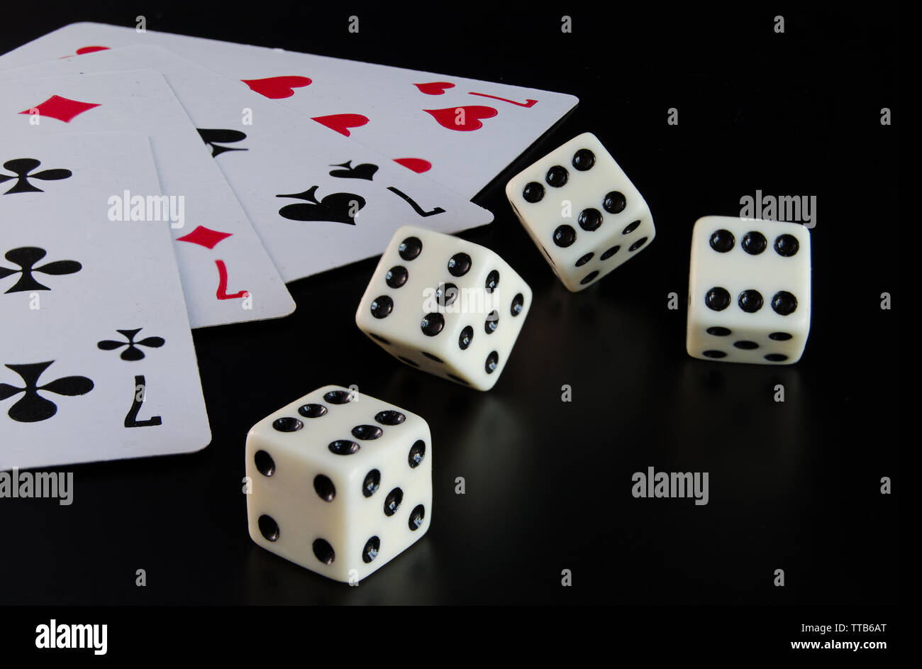 Dice, playing cards on a black background thrown on the table Stock Photo