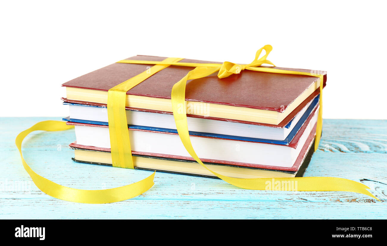 Stack of books with ribbon on table isolated on white Stock Photo - Alamy