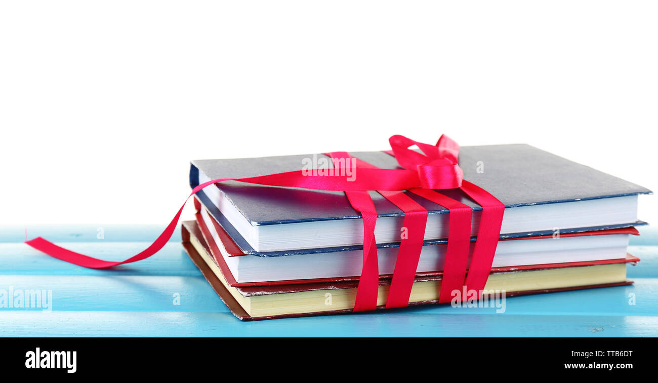 Stack of books with ribbon on table isolated on white Stock Photo - Alamy