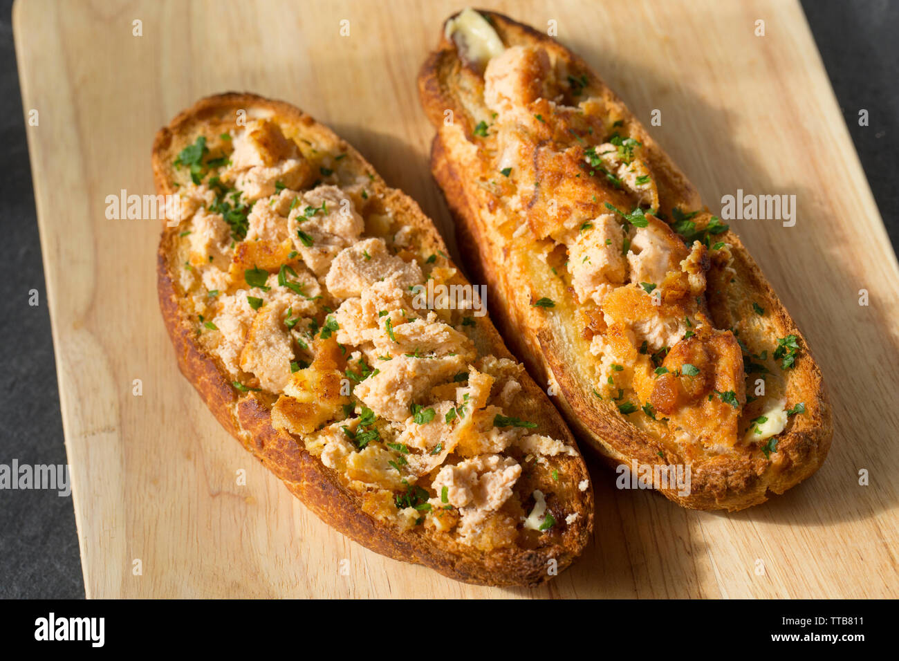 Cod roes that have been dipped in egg and then flour and breadcrumbs and fried in butter before being spread on toasted bread and garnished with parsl Stock Photo