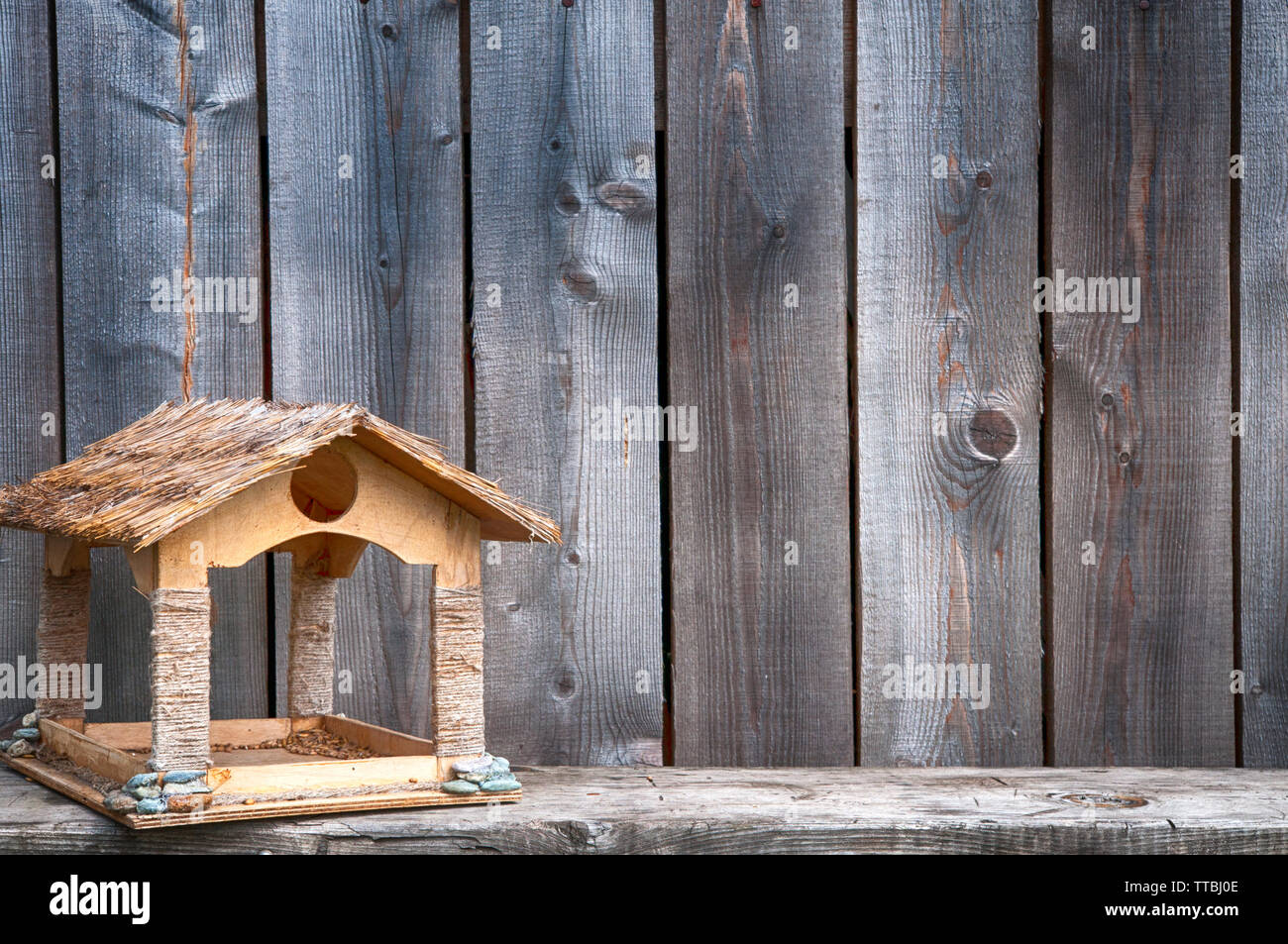 Wooden Bird Feeder On The Background Of The Wall Of Boards Stock
