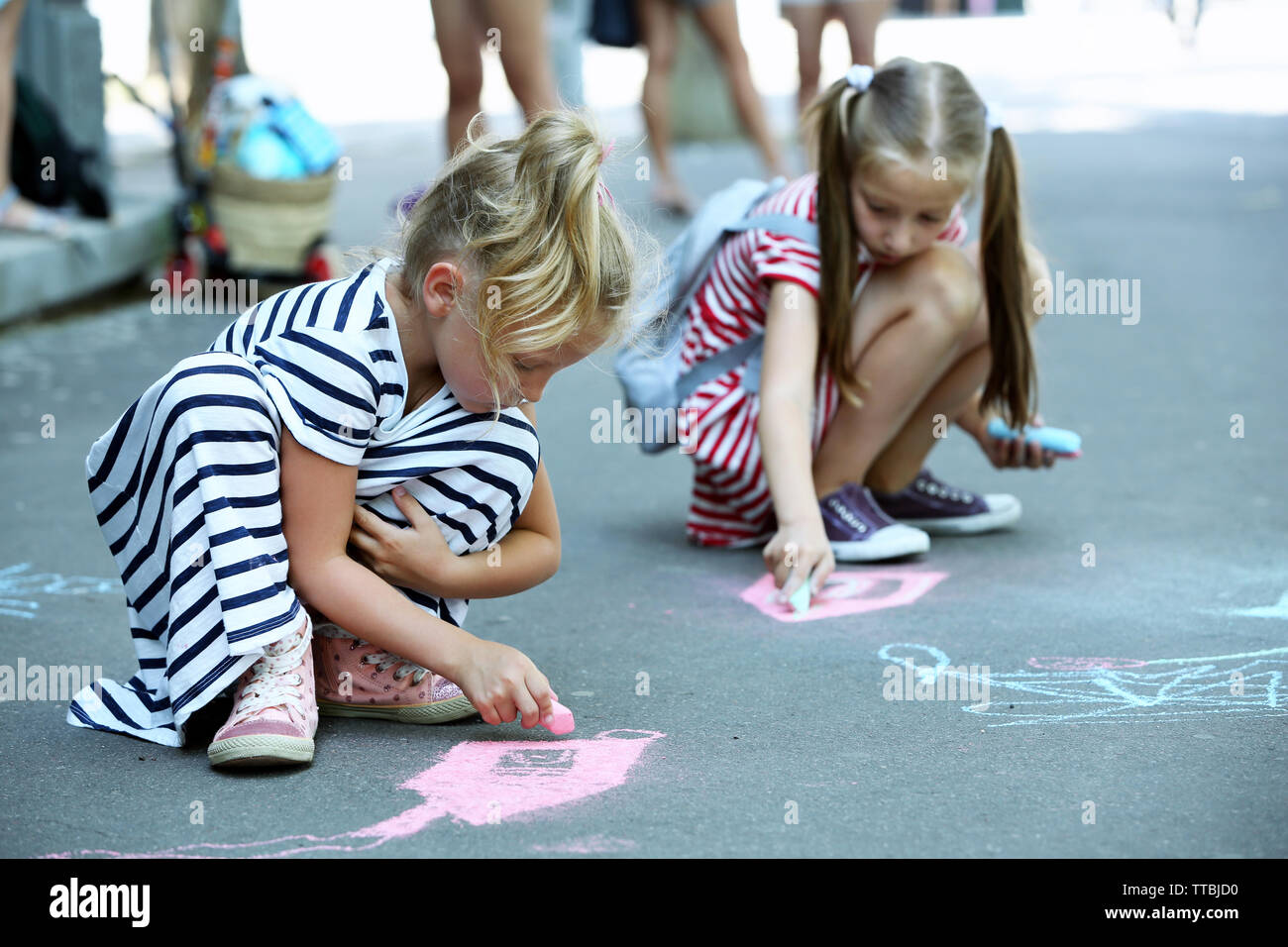 Happy active children drawing with chalk on asphalt Stock Photo - Alamy