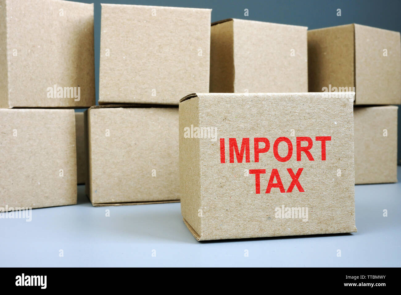 Import tax red stamp on cardboard box. Stock Photo
