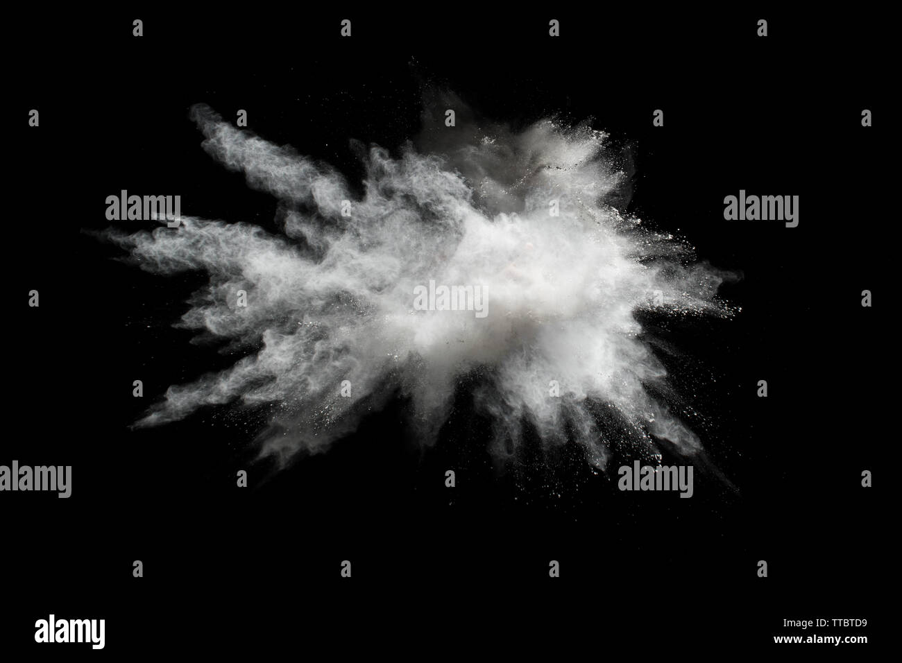 White powder explosion.Freeze motion of white dust particles on black background. Stock Photo