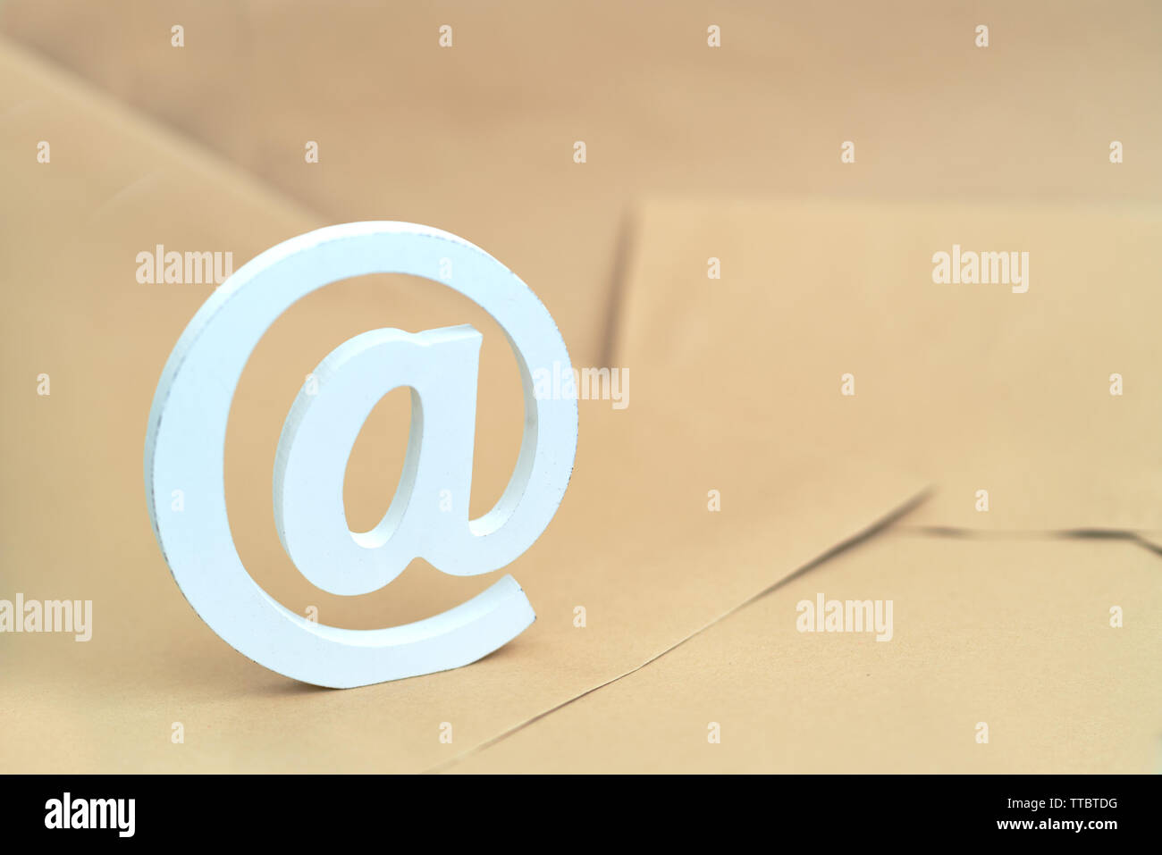 Email simbol at sign on brown envelopes background Stock Photo - Alamy