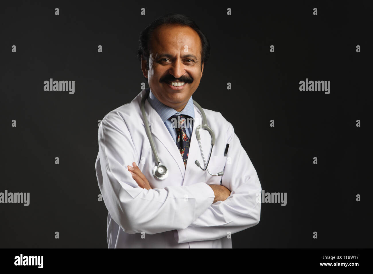 Portrait of a male doctor smiling with arms crossed Stock Photo - Alamy
