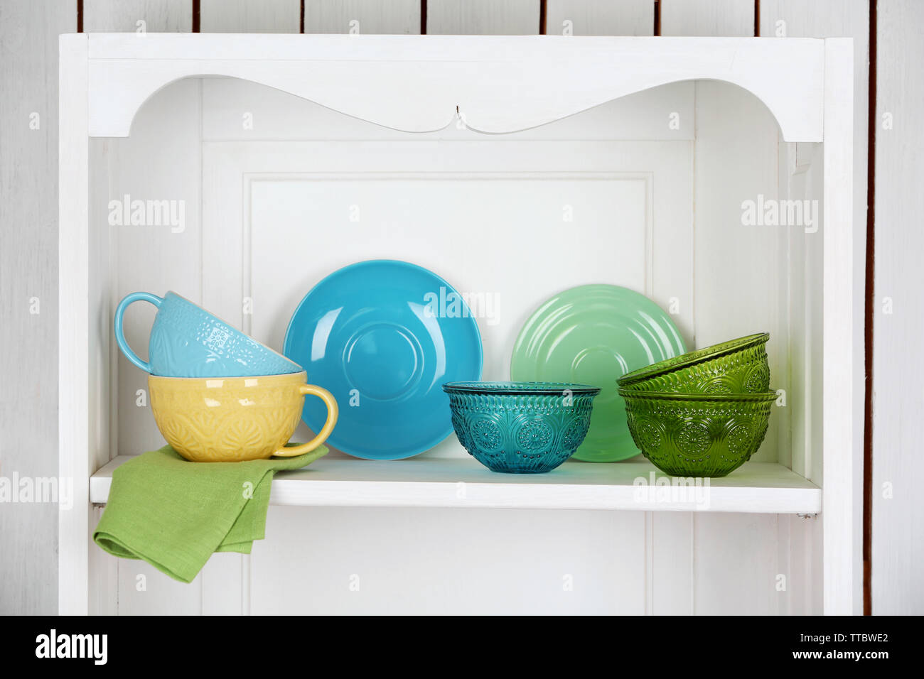 White kitchen cupboard with glasses, cups and bowls. Pastelles Stock Photo  - Alamy