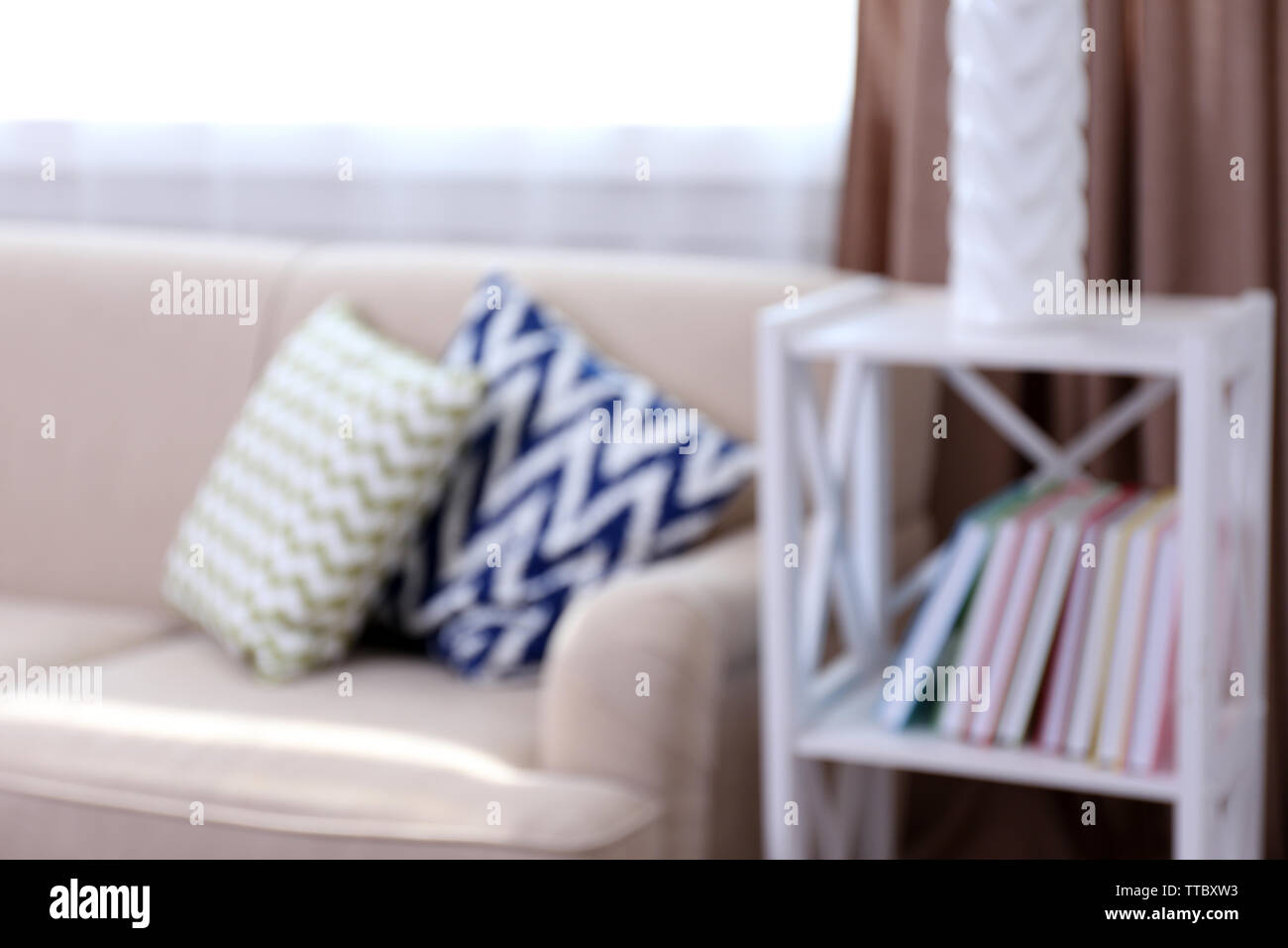 Comfortable sofa  with different pillows in the room, unfocused Stock Photo