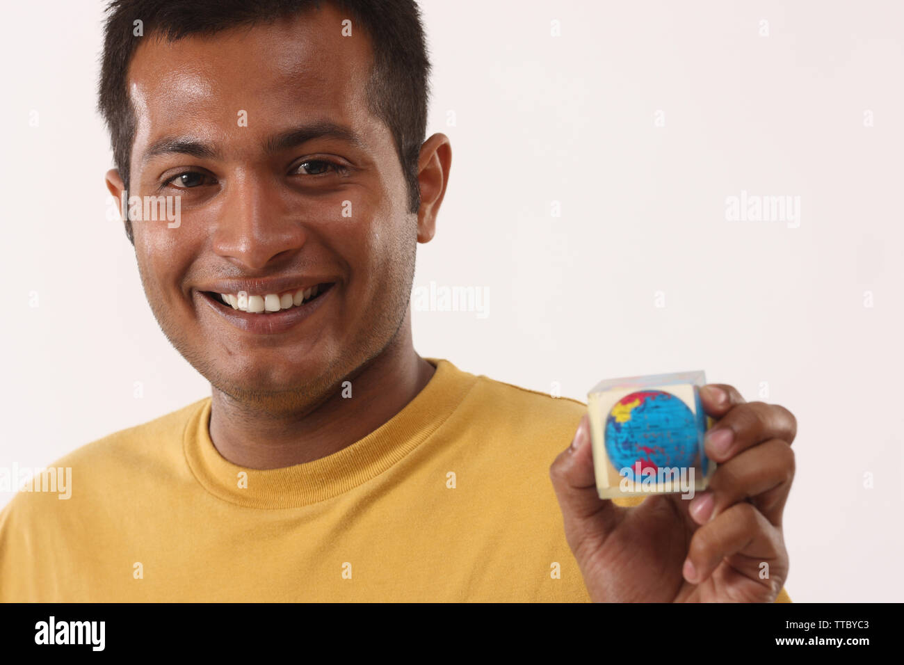 Young man showing a paperweight and smiling Stock Photo