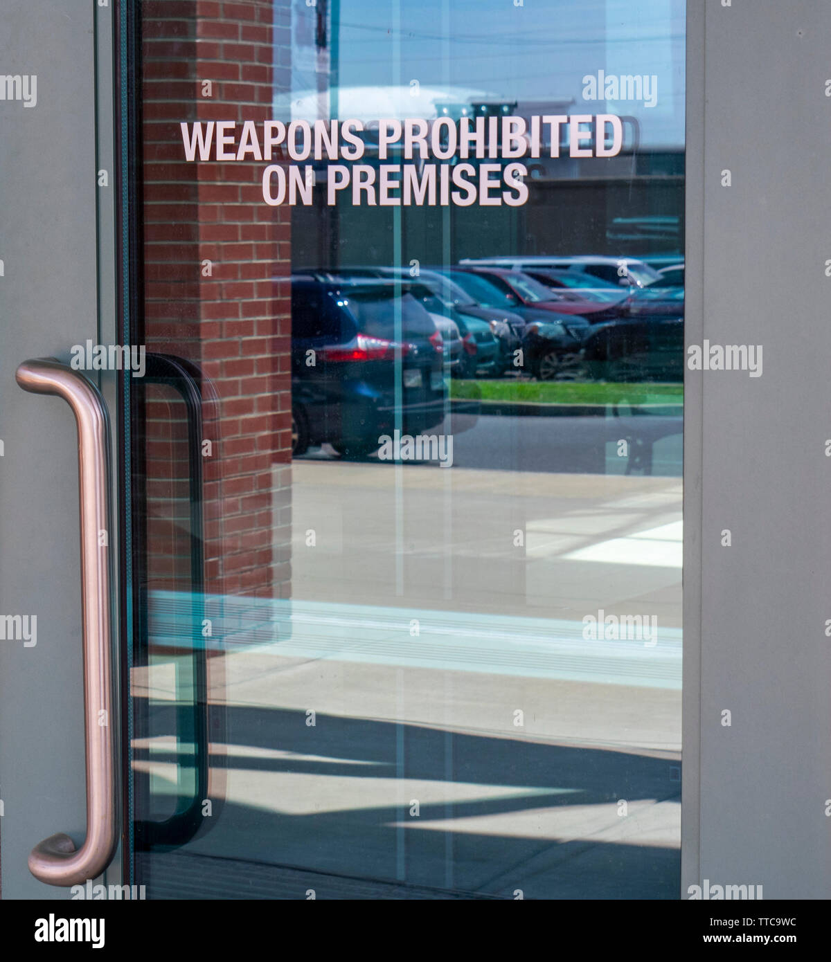Weapons Prohibited on premises sign on glass door entrance to