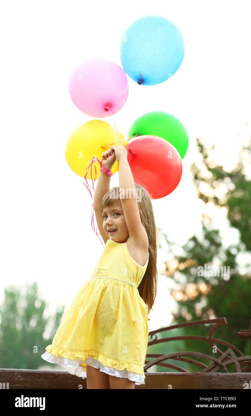 Little girl with balloons outside Stock Photo - Alamy