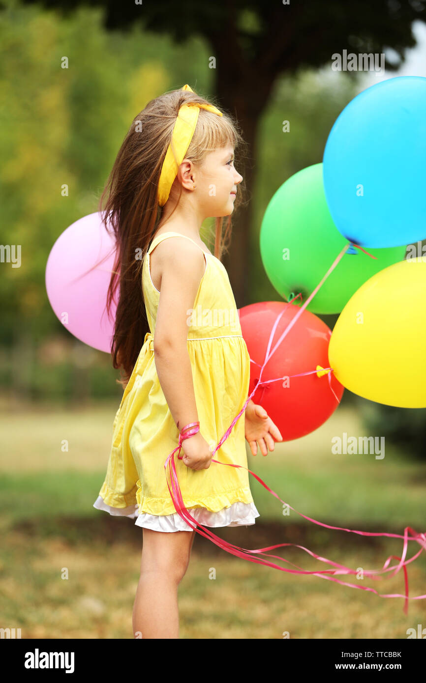 Little girl with balloons outside Stock Photo - Alamy