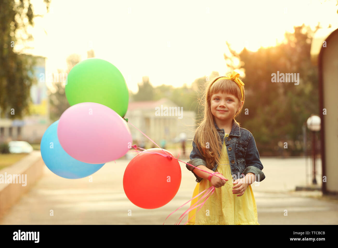 Little girl with balloons outside Stock Photo - Alamy