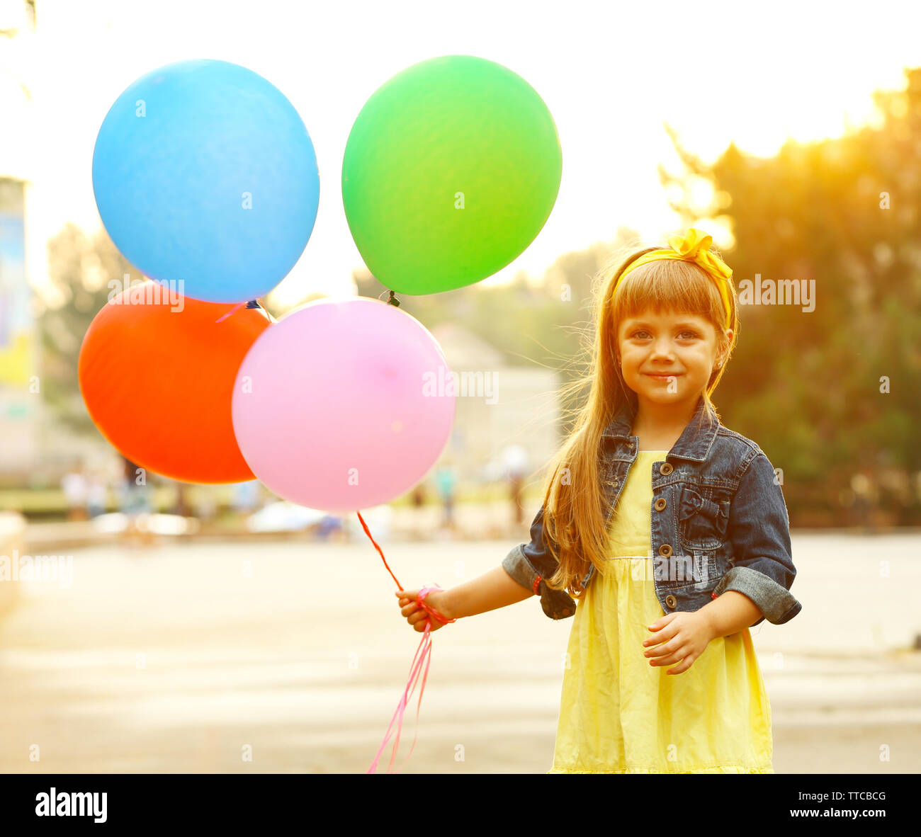 Little girl with balloons outside Stock Photo - Alamy