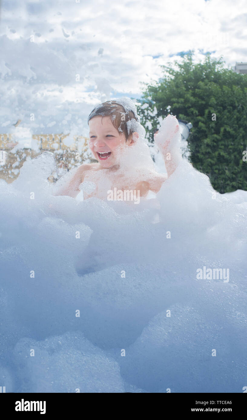 3 years boy enjoying at foam party outdoors. Active leisure on summer season for children Stock Photo