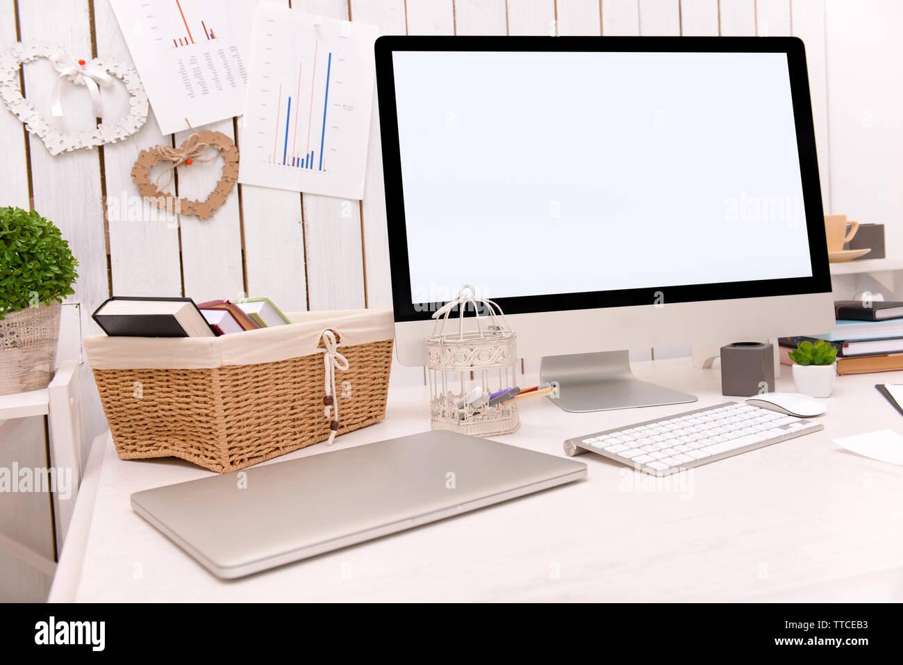 Modern computer on decorated table against wooden wall Stock Photo - Alamy