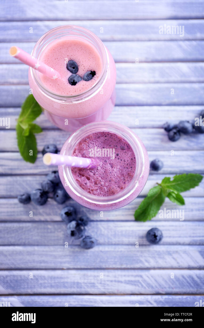 Delicious blueberry and strawberry yogurt with tubule on light wooden