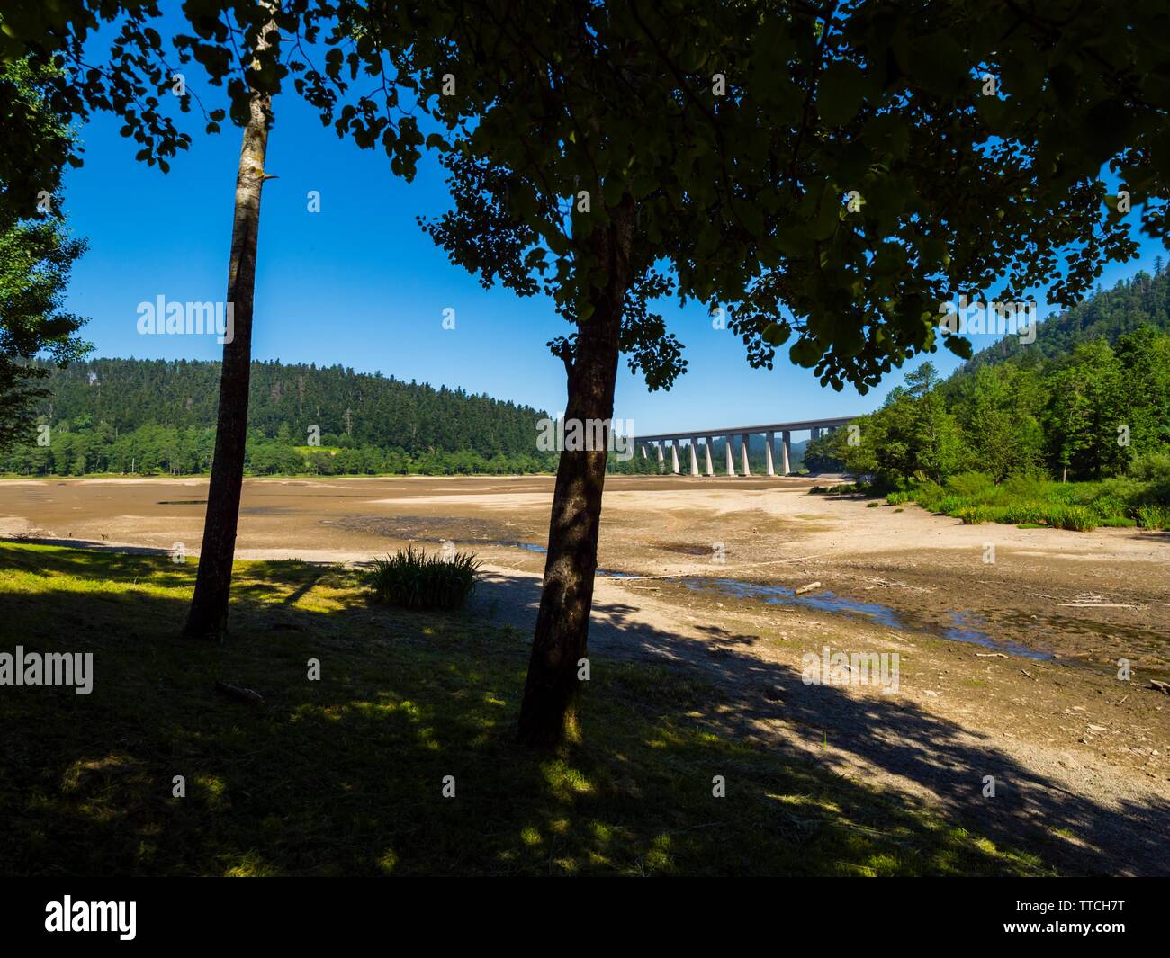 Dried lake-bed Bajer in Fuzine Croatia Spring 2019 highway bridge in background Stock Photo