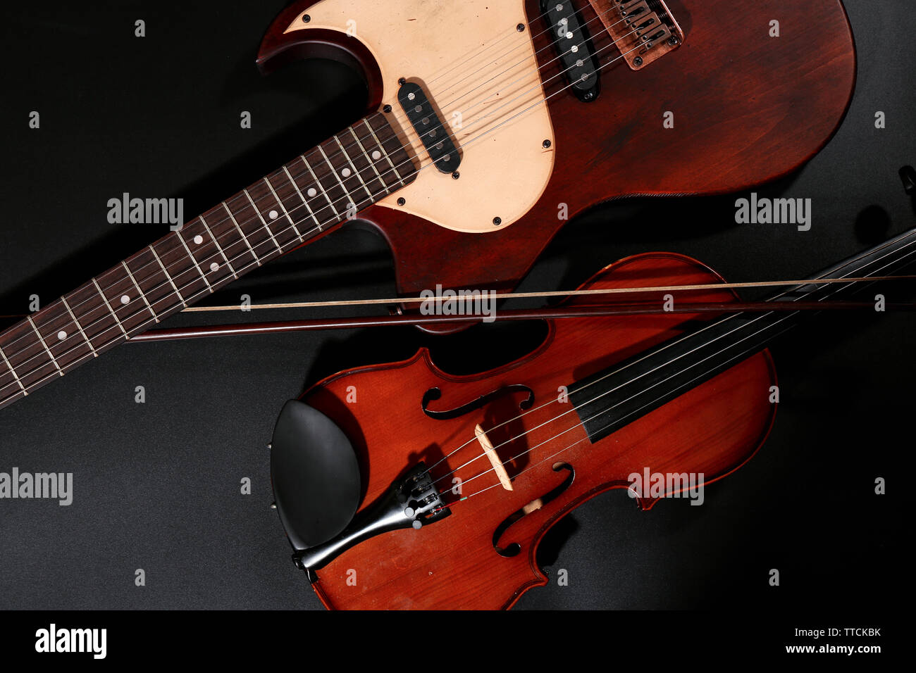 Electric guitar and violin on grey background Stock Photo - Alamy