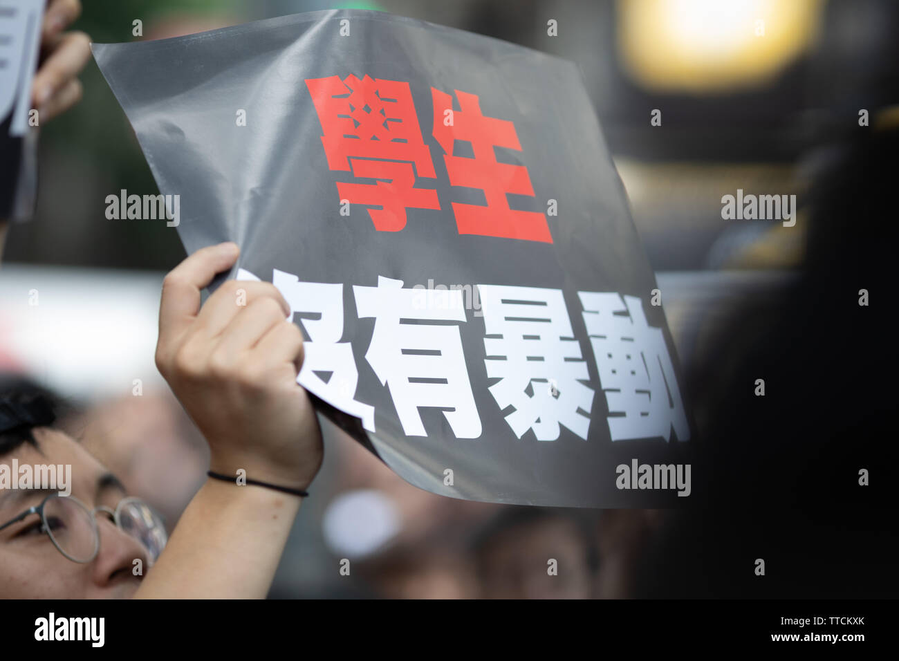 Hong Kong, Hong Kong. 16 June, 2019. A holds up a sign decrying police violence of previous marches and their declaration as a riot. Credit: Danny Tsai/Alamy Live News Stock Photo