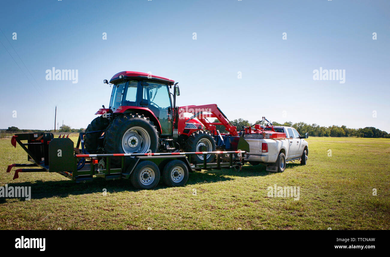 Texas farming delivering/towing a large red tractor Stock Photo Alamy