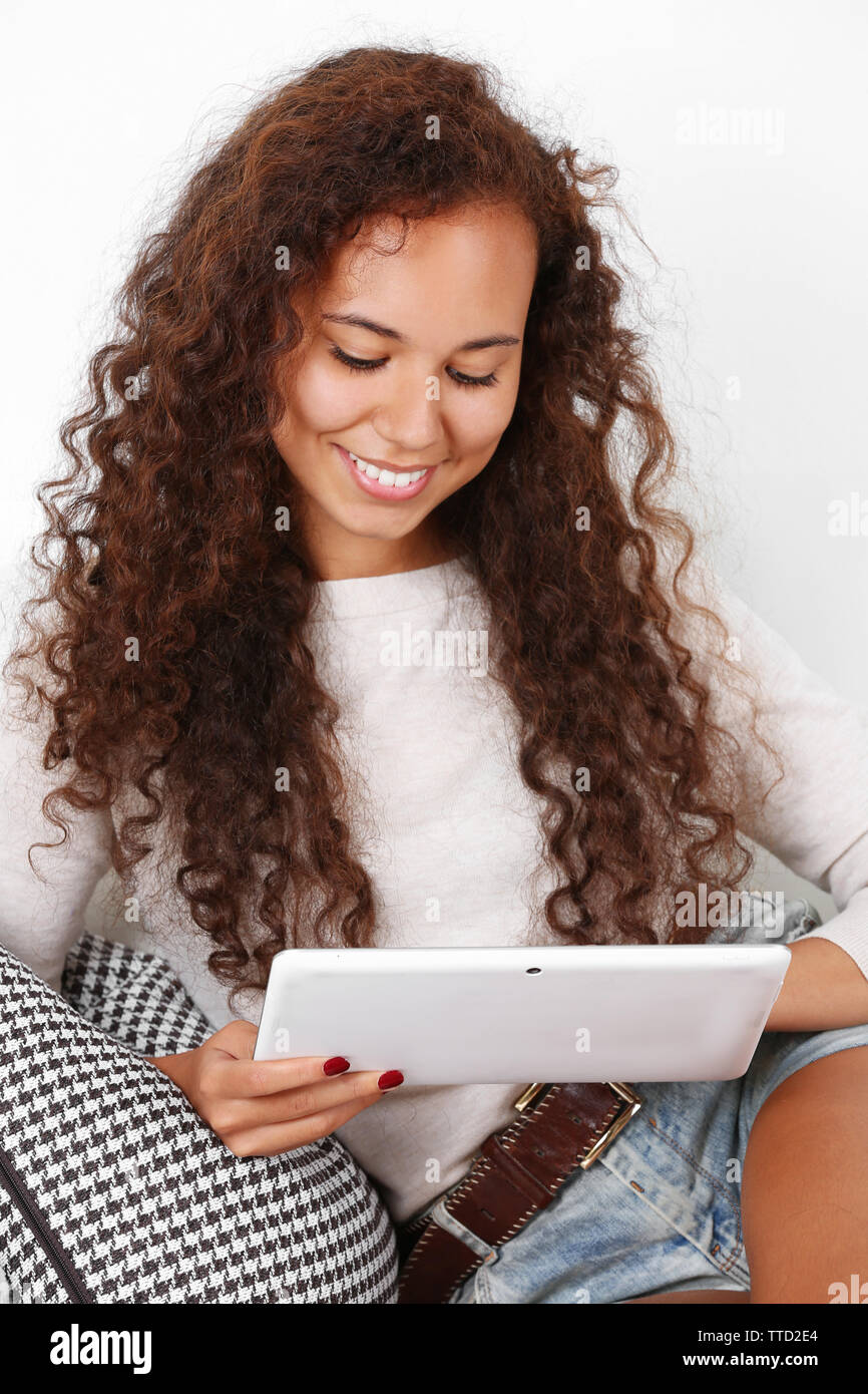 Pretty woman sitting on sofa with white tablet Stock Photo - Alamy