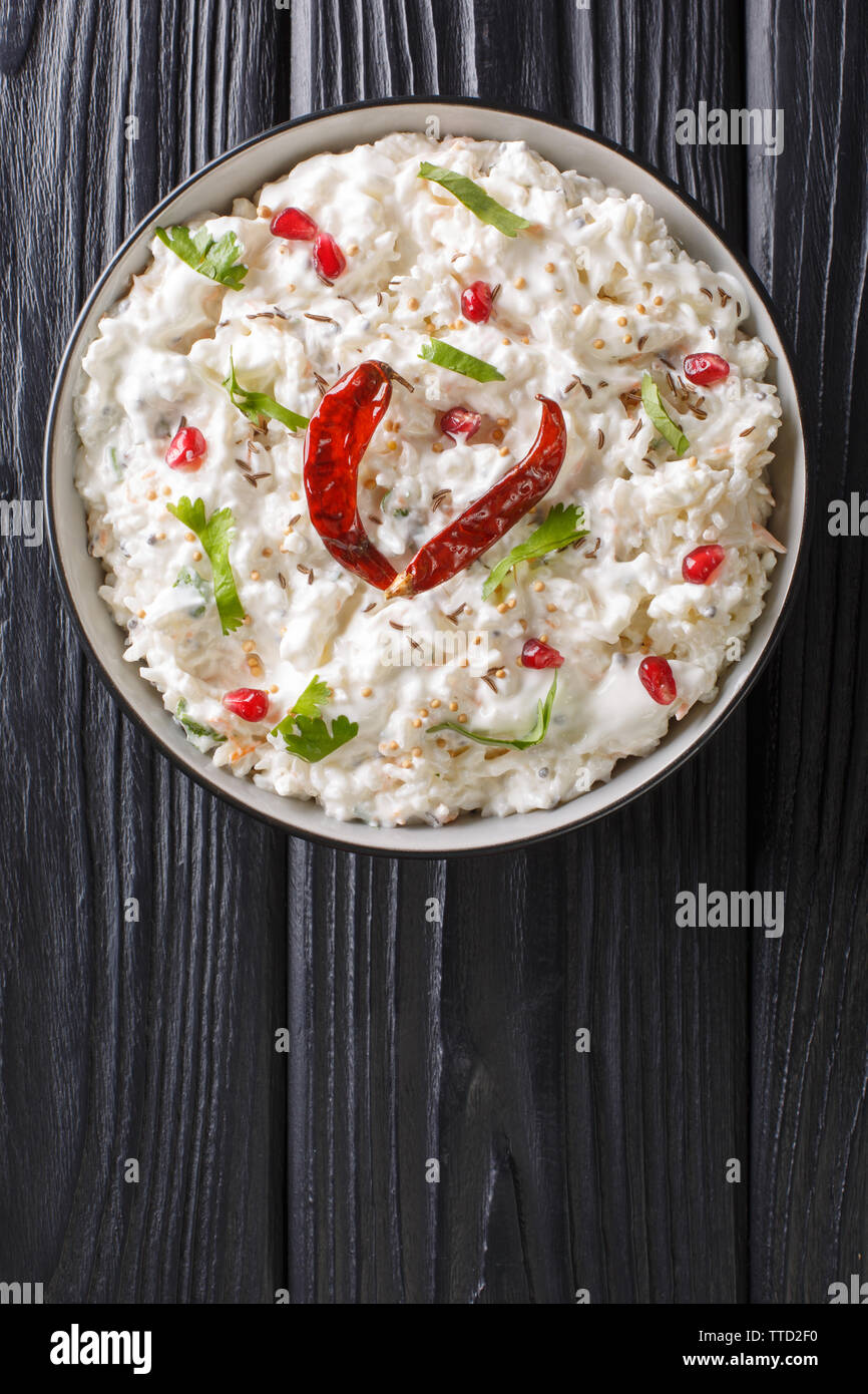 Comforting Curd Rice is a popular dish from South India with yogurt and then tempered with spices closeup in a plate on the table. Vertical top view f Stock Photo