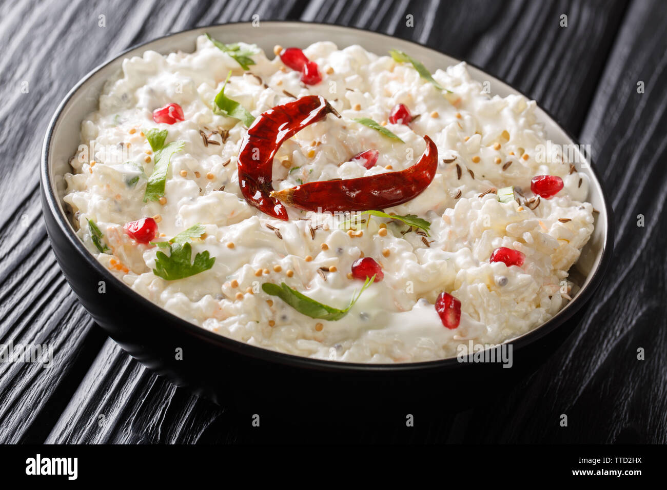 Indian Curd rice with carrots, pomegranate and with additional tempering of spices close-up in a plate on the table. horizontal Stock Photo