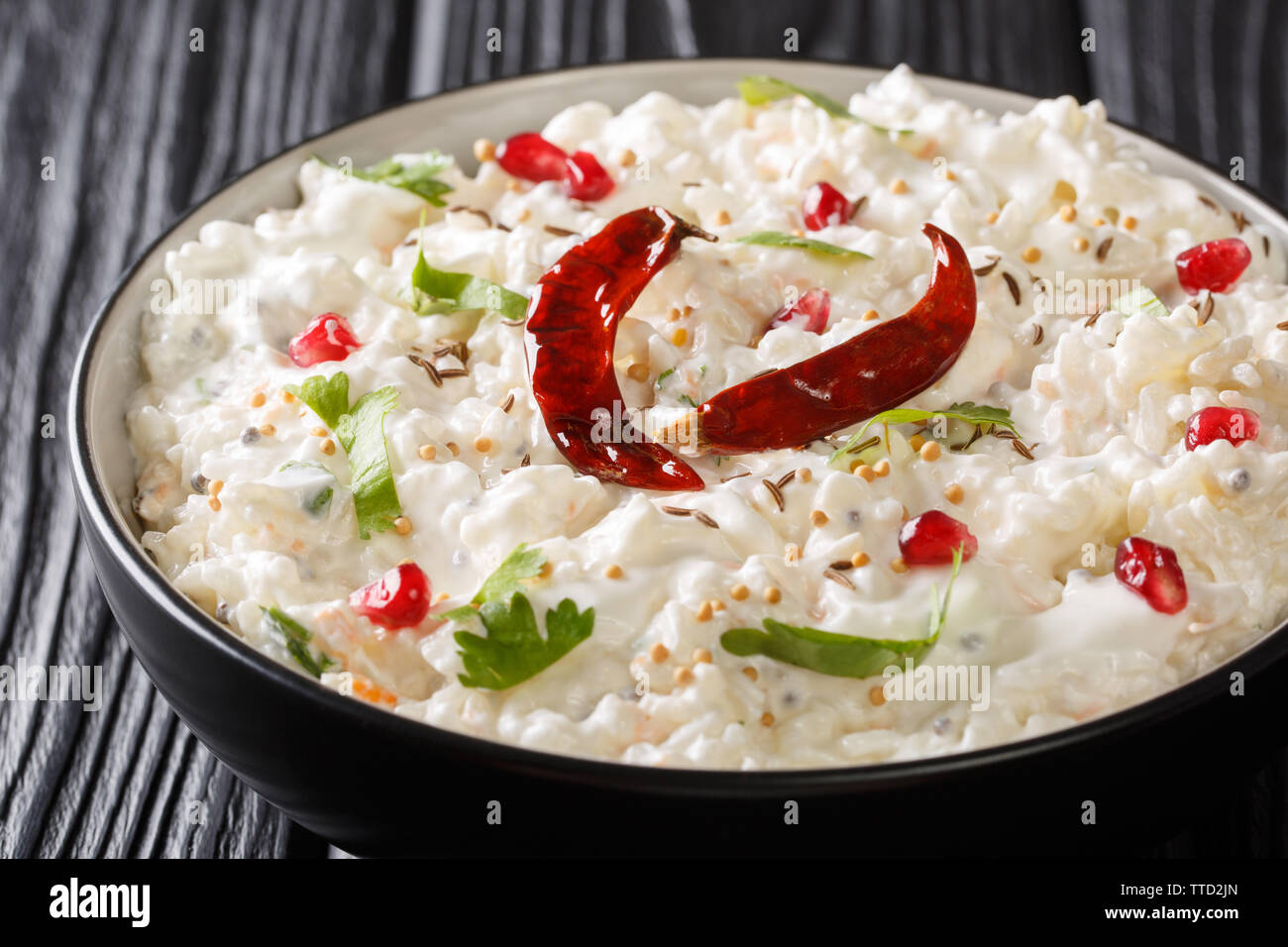 Thayir Saadam (Curd Rice) Recipe where  steamed rice and plain curd or with additional tempering of spices closeup in a plate on the table. horizontal Stock Photo