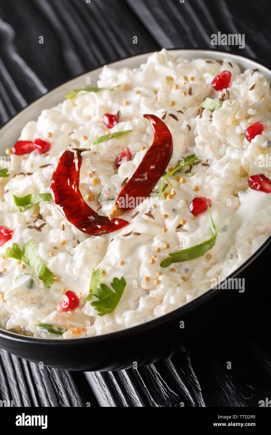 Comforting Curd Rice is a popular dish from South India with yogurt and then tempered with spices closeup in a plate on the table. Vertical Stock Photo