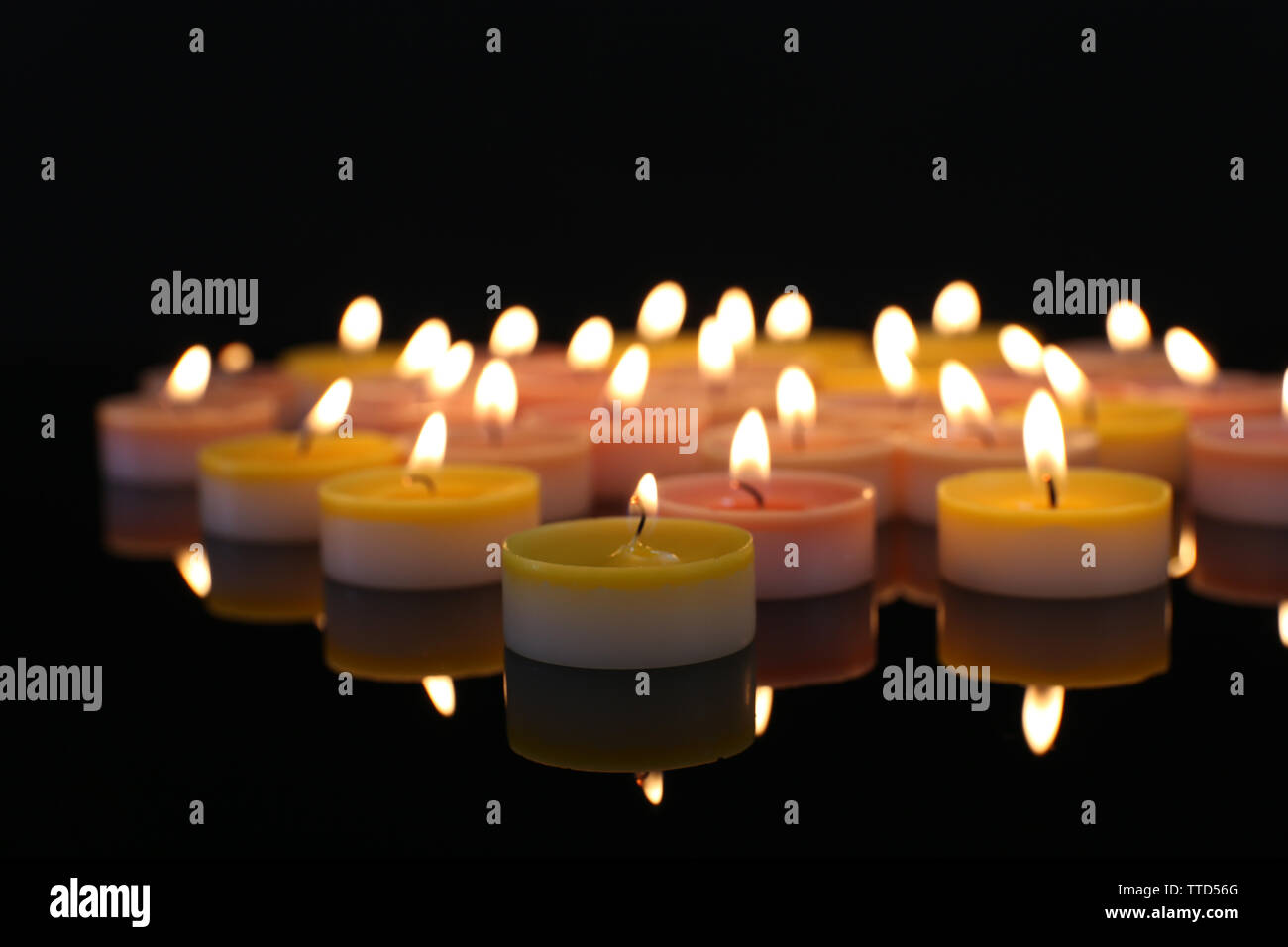 Many burning small candles on dark background Stock Photo - Alamy