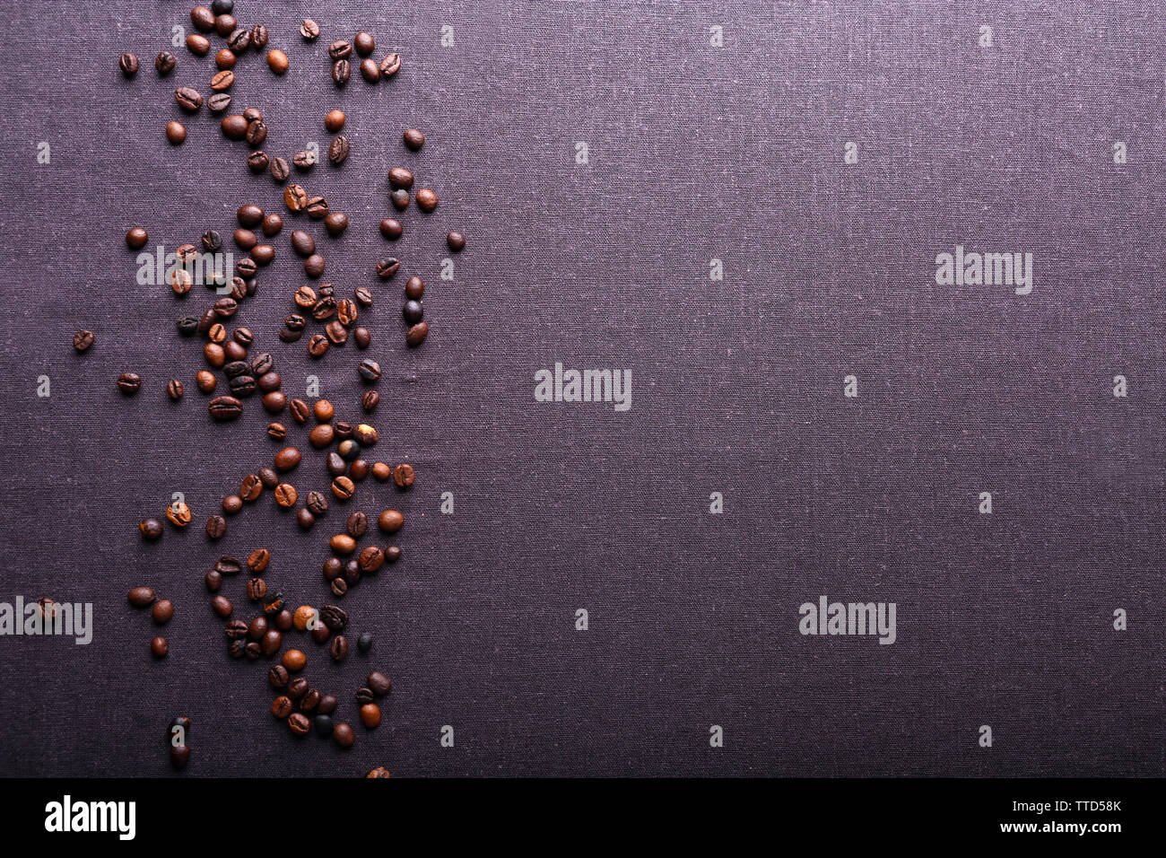 Roasted coffee beans on grey textile background Stock Photo - Alamy