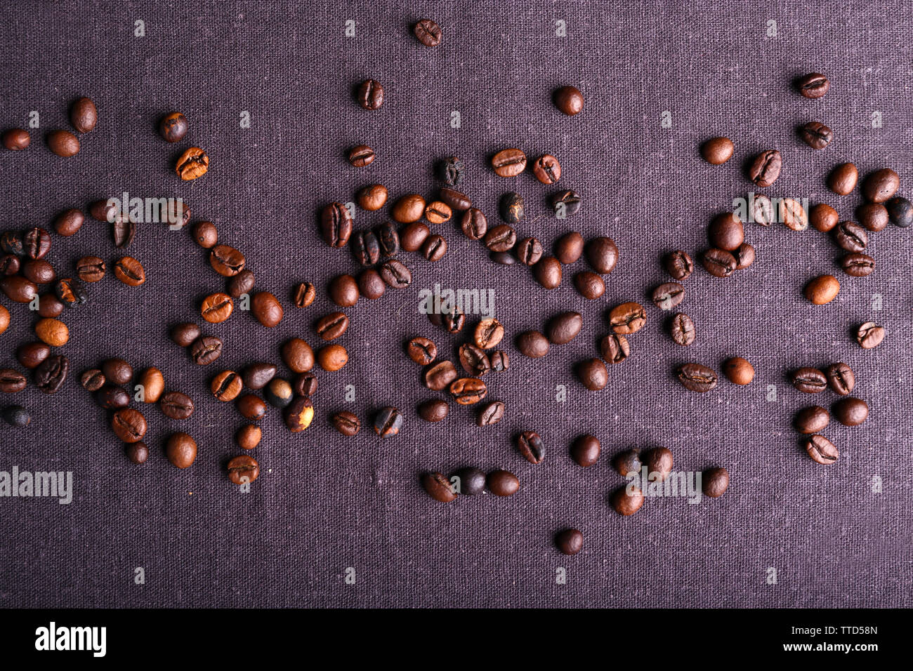 Roasted coffee beans on grey textile background Stock Photo - Alamy