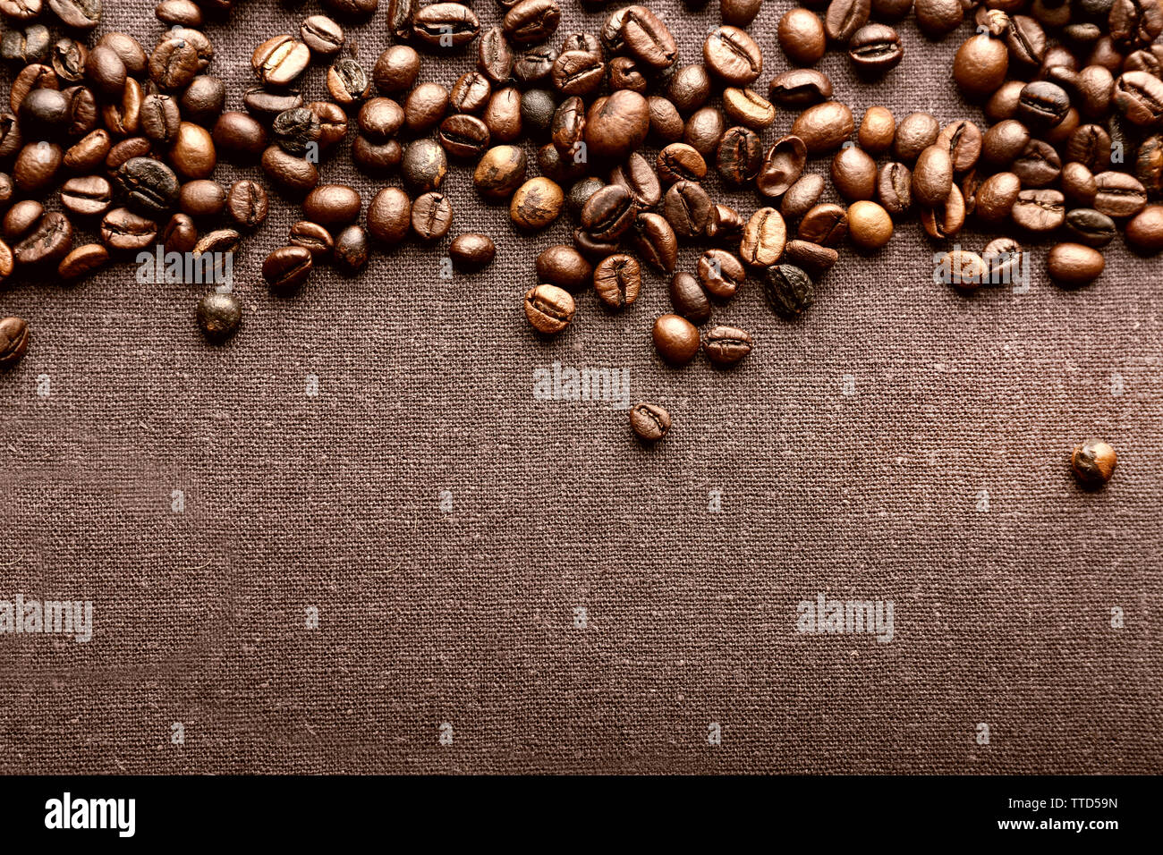 Roasted coffee beans on grey textile background Stock Photo - Alamy