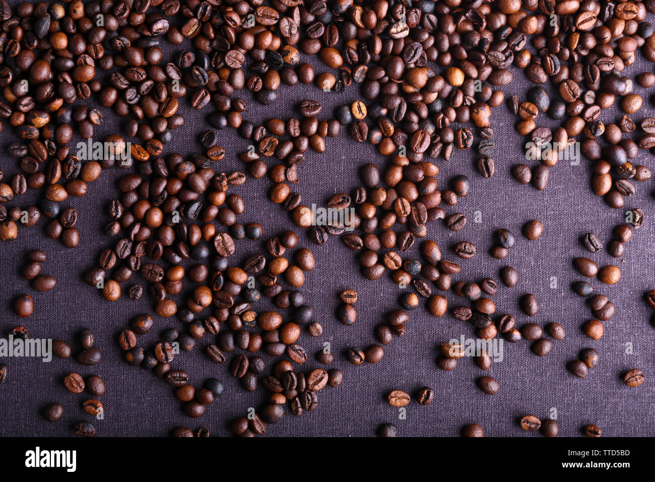 Roasted coffee beans on grey textile background Stock Photo - Alamy