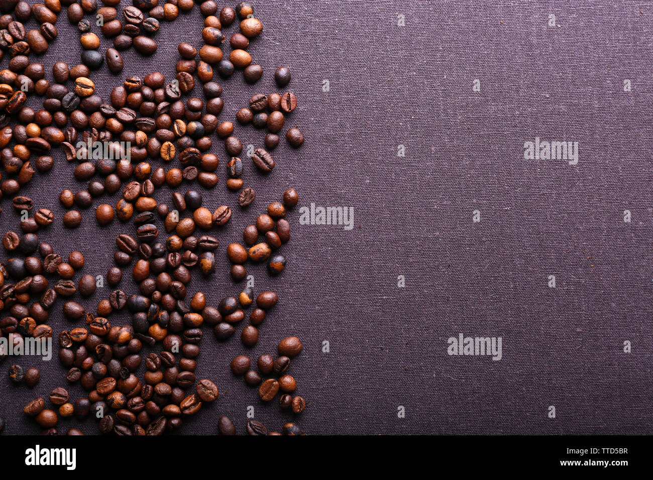 Roasted coffee beans on grey textile background Stock Photo - Alamy