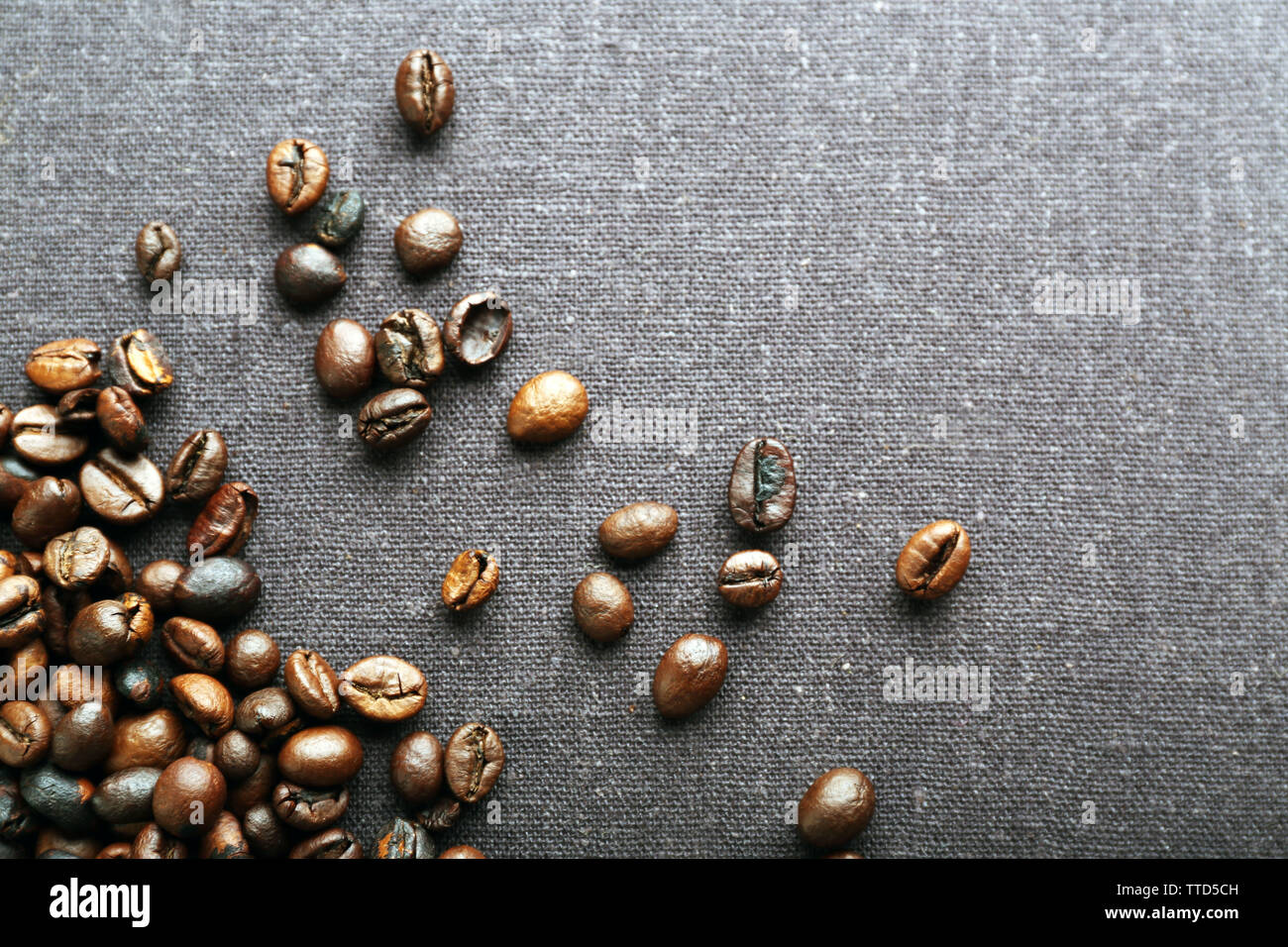 Roasted coffee beans on grey textile background Stock Photo - Alamy