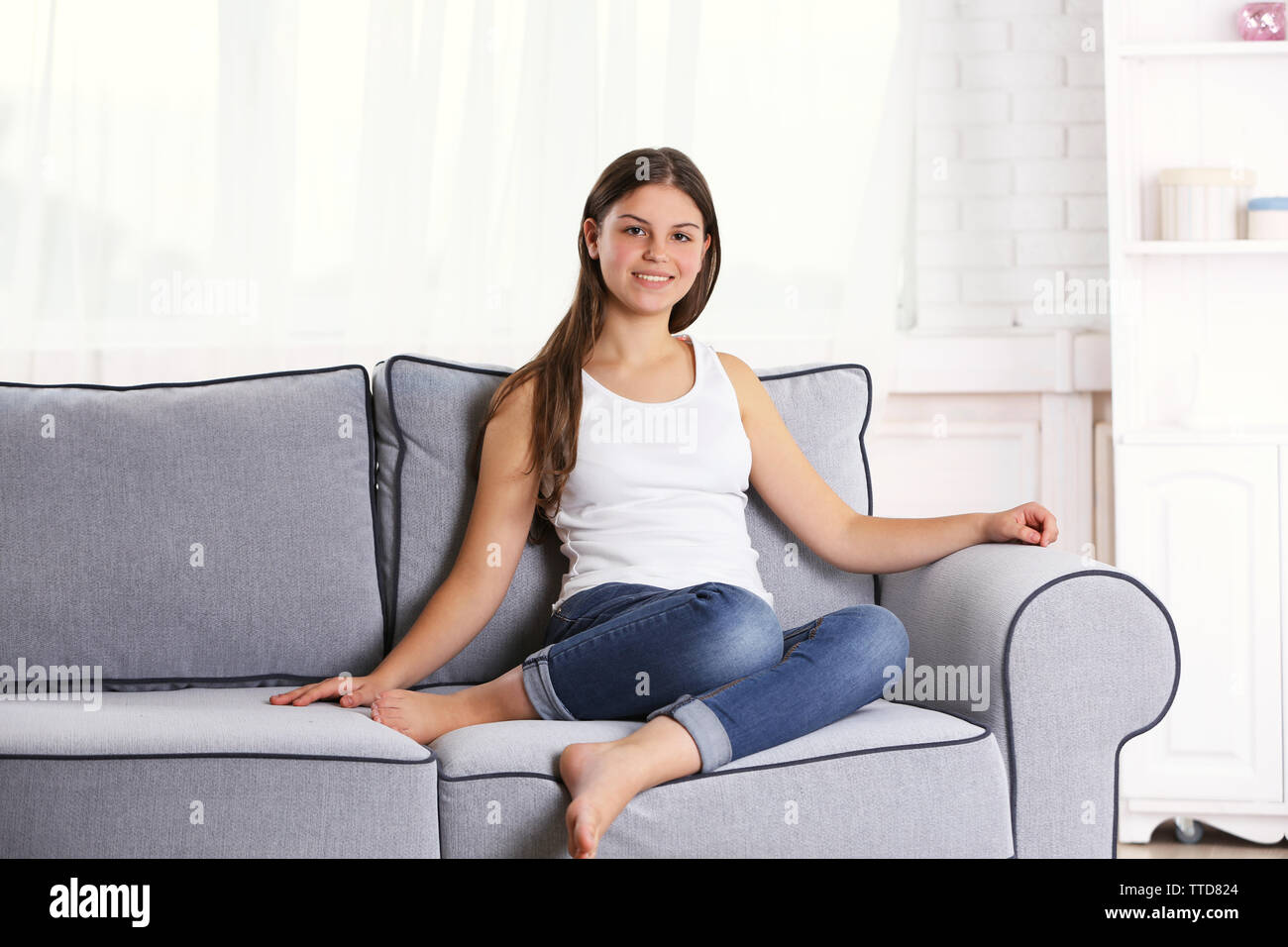 Portrait of young pretty girl sitting on the sofa in her room Stock ...